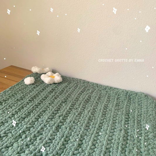 A green cat/small dog mat with small white flowers detailing the edge of the mat.