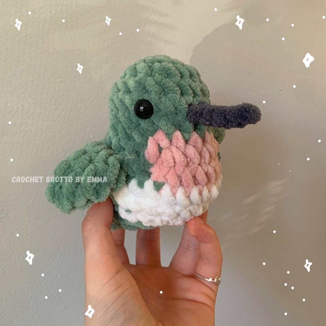 A crochet ruby-throated hummingbird plushie showing a diagonal right-side/front angle.