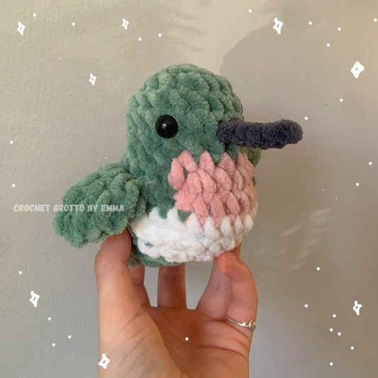A crochet ruby-throated hummingbird plushie showing a diagonal right-side/front angle.