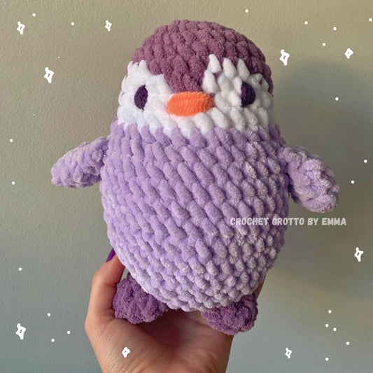 A purple crochet penguin plushie from the front.