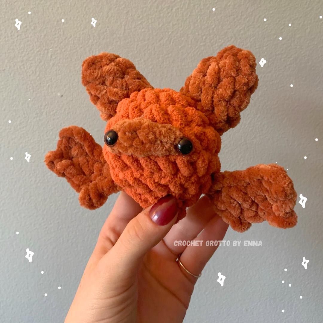 An eastern red bat crochet plushie, pictured from the front.